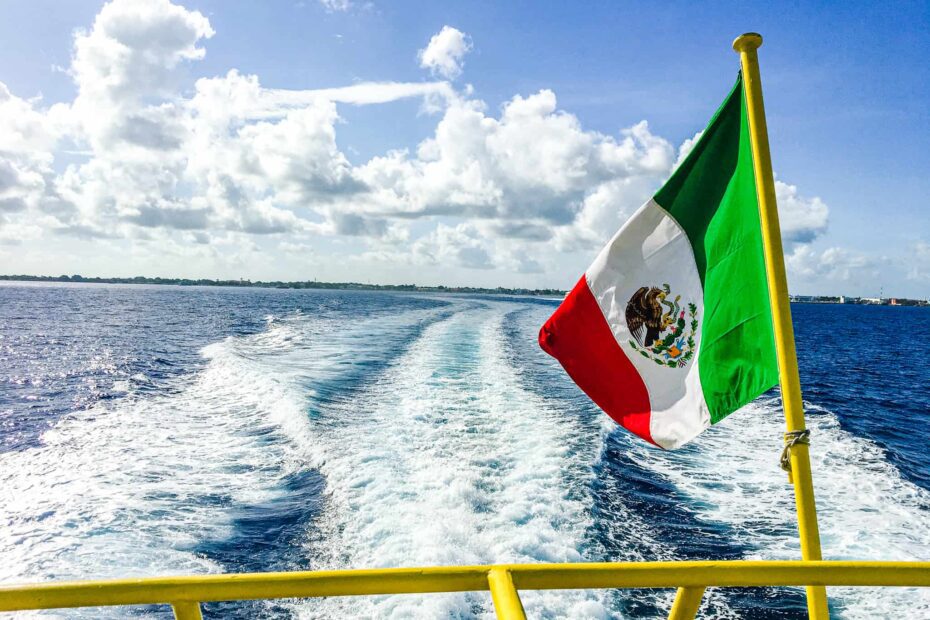 Mexican flag on the back of a ferry overlooking a favorite Mexico Vacation Spot, the island of Cozumel
