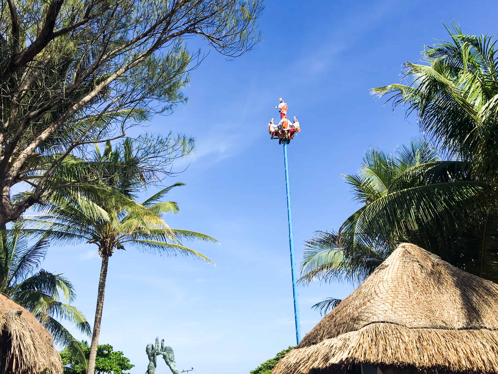 sky performers on a high pole performing in Playa Del Carmen's pier