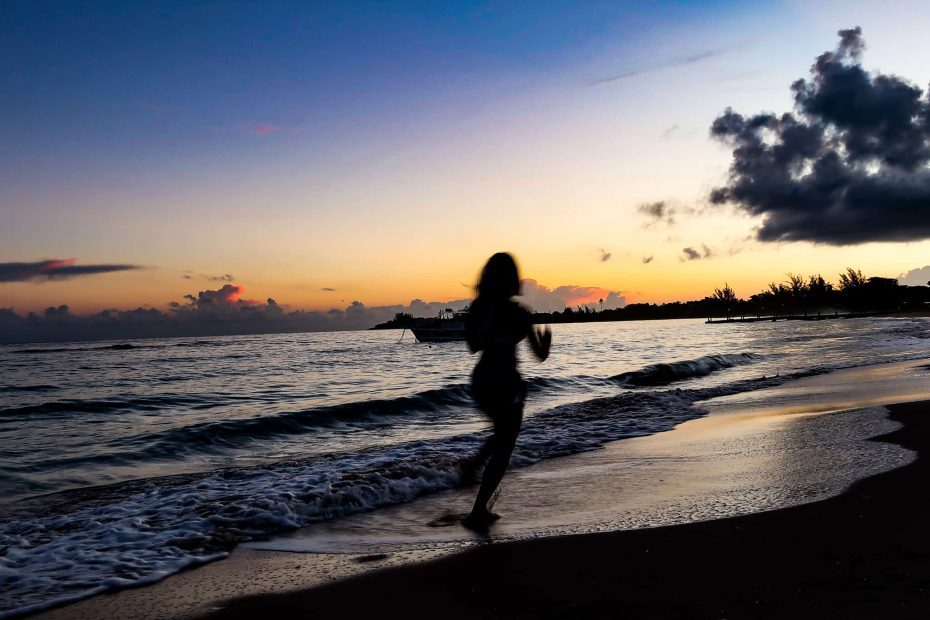 female silhouette running on the beach to keep fit