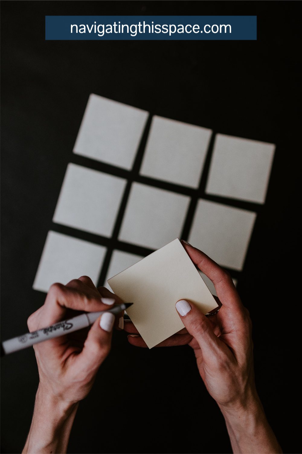 hands writing on a sticky pad