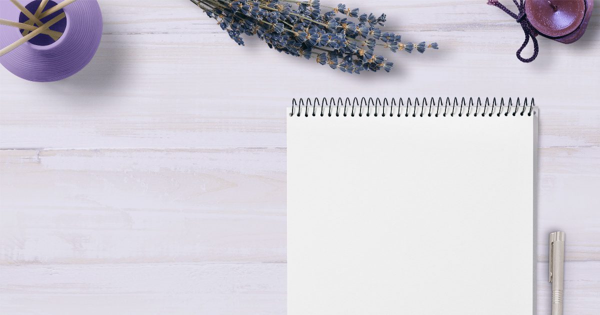 blank notebook with pen and lavender plant on a table