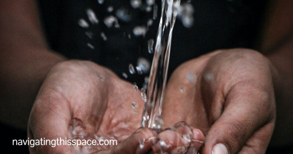 hands catching a stream of water