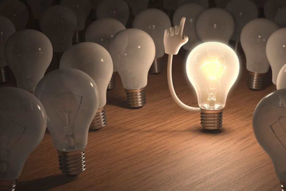 a lit light bulb with its hand up surrounded by light bulbs with no lights