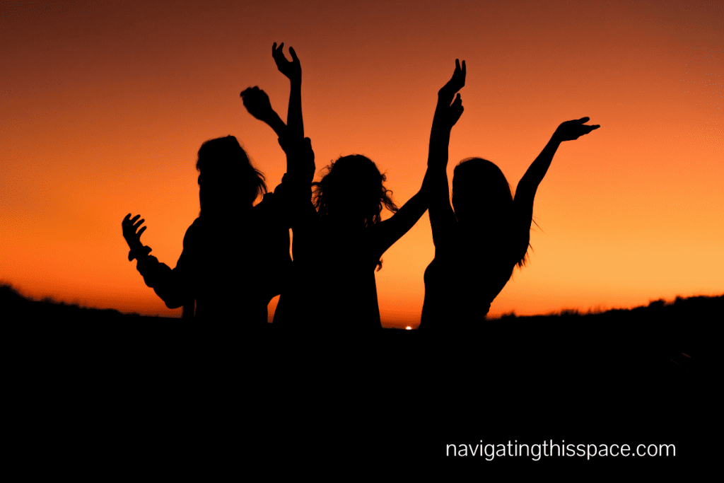 Silhouette of 3 women dancing at sunset 