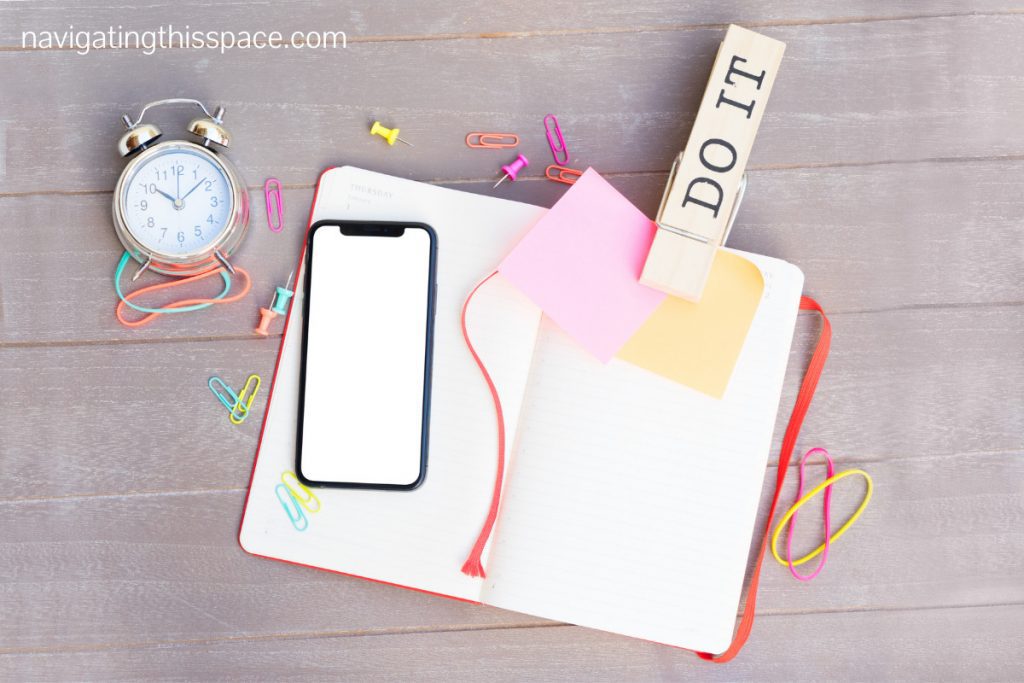 note book. cell phone and a clock kept for journal scheduling.