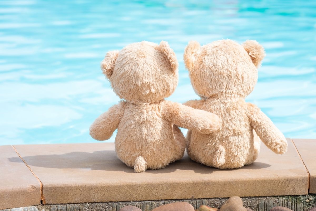 two stuffed animals hugging by the pool