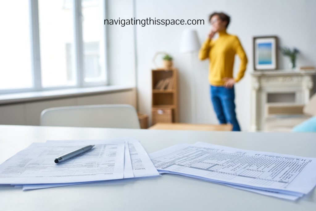 sheets of paper on a desk with a figure in the background on the phone